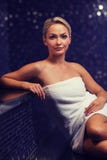 Schöne junge Frau, die im Badtuch sitzt Stockbild Schöne junge Frau, die im Badtuch sitzt Stockbild