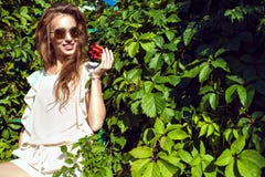 Schöne lächelnde Frau in der modischen Runde spiegelte die Sonnenbrille wider, die auf der Leiter an der Virginia-Kriechpflanzenh stockfotografie Schöne lächelnde Frau in der modischen Runde spiegelte die Sonnenbrille wider, die auf der Leiter an der Virginia-Kriechpflanzenh stockfotografie