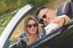 Schöne Paare, die Selbstporträt von ihrem Cabrioletauto in der Natur nehmen stockbilder Schöne Paare, die Selbstporträt von ihrem Cabrioletauto in der Natur nehmen stockbilder