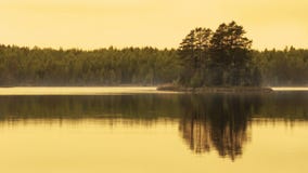 Schöne Reflexion der goldenen Stunde von kleiner Insel im See stockfotografie Schöne Reflexion der goldenen Stunde von kleiner Insel im See stockfotografie