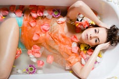 Recht sexy Mädchen, das ein Bad mit den Blumenblumenblättern nimmt stockbild Recht sexy Mädchen, das ein Bad mit den Blumenblumenblättern nimmt stockbild