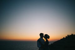 Schöner Paarmann und -frau auf dem Sonnenuntergang auf dem Meer lizenzfreies stockbild Schöner Paarmann und -frau auf dem Sonnenuntergang auf dem Meer lizenzfreies stockbild