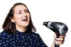 Schönes Brunettemädchen mit Augen schloss das Schreien, in ein Isolat Hairdryer die blauen Hemdglückgefühle an Hand singend stockfotos Schönes Brunettemädchen mit Augen schloss das Schreien, in ein Isolat Hairdryer die blauen Hemdglückgefühle an Hand singend stockfotos