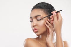 Schönes Mulattemädchen tut hübsches Make-up lizenzfreie stockfotografie Schönes Mulattemädchen tut hübsches Make-up lizenzfreie stockfotografie
