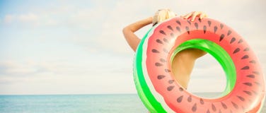 Schönes Mädchen mit aufblasbarem Ring steht auf dem Strand und betrachtet das Meersommerferien Fahnenkonzept stockbild Schönes Mädchen mit aufblasbarem Ring steht auf dem Strand und betrachtet das Meersommerferien Fahnenkonzept stockbild