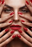 Schönes Mädchen mit einem klassischen Make-up und roten Nägeln Maniküredesign Schönes lächelndes Mädchen lizenzfreie stockfotografie Schönes Mädchen mit einem klassischen Make-up und roten Nägeln Maniküredesign Schönes lächelndes Mädchen lizenzfreie stockfotografie