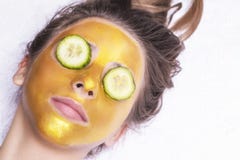Schönes Mädchen mit einer kosmetischen Maske auf dem Gesicht der goldenen Farbe Nahaufnahme Freier Raum Frauengoldmaske Schönes M lizenzfreies stockfoto Schönes Mädchen mit einer kosmetischen Maske auf dem Gesicht der goldenen Farbe Nahaufnahme Freier Raum Frauengoldmaske Schönes M lizenzfreies stockfoto