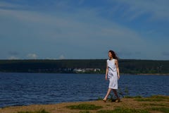 Schönheit im weißen Kleid gehend nahe der Flussbank lizenzfreie stockbilder Schönheit im weißen Kleid gehend nahe der Flussbank lizenzfreie stockbilder