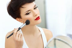 Schönheits-Mädchen mit Make-upbürste. Natürlich machen Sie Brunette-Frau mit den roten Lippen wieder gut. Lizenzfreies Stockfoto Schönheits-Mädchen mit Make-upbürste. Natürlich machen Sie Brunette-Frau mit den roten Lippen wieder gut. Lizenzfreies Stockfoto