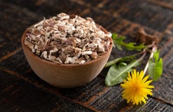 Schüssel der entwässerten Löwenzahn-Wurzel auf einem rustikalen Holztisch stockfotografie Schüssel der entwässerten Löwenzahn-Wurzel auf einem rustikalen Holztisch stockfotografie