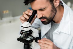 Scientifique masculin dans le manteau blanc fonctionnant avec le microscope dans le laboratoire chimique photo libre de droits Scientifique masculin dans le manteau blanc fonctionnant avec le microscope dans le laboratoire chimique photo libre de droits
