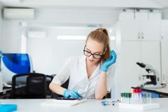 Scientist analyzing microscope slide at laboratory. Female Working in Laboratory With Microscope. Researcher examining Royalty Free Stock Photos Scientist analyzing microscope slide at laboratory. Female Working in Laboratory With Microscope. Researcher examining Royalty Free Stock Photos