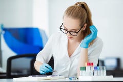 Scientist analyzing microscope slide at laboratory. Female Working in Laboratory With Microscope. Researcher examining Royalty Free Stock Images Scientist analyzing microscope slide at laboratory. Female Working in Laboratory With Microscope. Researcher examining Royalty Free Stock Images