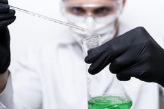 The scientist`s hands hold a flask and a test tube with a bright green liquid. royalty free stock image The scientist`s hands hold a flask and a test tube with a bright green liquid. royalty free stock image