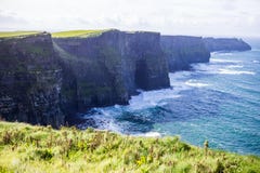 Scogliere di Moher all'oceano di Alantic in Irlanda occidentale con le onde che battono contro le rocce immagine stock libera da diritti Scogliere di Moher all'oceano di Alantic in Irlanda occidentale con le onde che battono contro le rocce immagine stock libera da diritti