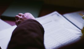 Scrolling through a sheet of paper. Hands of a man over a sheet of paper. stock photo Scrolling through a sheet of paper. Hands of a man over a sheet of paper. stock photo