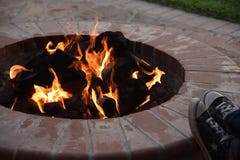 Se reposer autour du puits du feu d'arrière-cour une nuit chaude photo stock Se reposer autour du puits du feu d'arrière-cour une nuit chaude photo stock