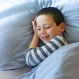 Se réveiller heureux d'enfant photographie stock libre de droits Se réveiller heureux d'enfant photographie stock libre de droits