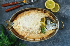 Sea Fish, Dorado Fish Baked In Coarse Salt Mixed With Egg White. Healthy Food. Top View. Stock Photo Sea Fish, Dorado Fish Baked In Coarse Salt Mixed With Egg White. Healthy Food. Top View. Stock Photo