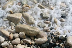 Sea foam on the beach pebbles stock photography Sea foam on the beach pebbles stock photography