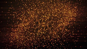 Gold sparkling glitter star dust trail. Golden shine light on black background.