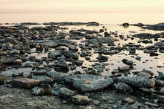 Seascape с плоским стеклом как море и утесами на береге на заходе солнца стоковое изображение rf Seascape с плоским стеклом как море и утесами на береге на заходе солнца стоковое изображение rf