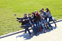 Seaside Park, Baku, Azerbaijan - March 29, 2017. A group of tourists taking a selfie in the seaside Park on the bench royalty free stock image Seaside Park, Baku, Azerbaijan - March 29, 2017. A group of tourists taking a selfie in the seaside Park on the bench royalty free stock image