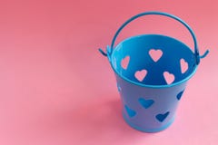 Seau bleu décoratif avec les trous en forme de coeur sur le fond rose Concept de fête photo libre de droits Seau bleu décoratif avec les trous en forme de coeur sur le fond rose Concept de fête photo libre de droits