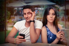 Secretive Couple with Smart Phones in Their Hands. Young adult couple has privacy problems with modern technology Secretive Couple with Smart Phones in Their Hands. Young adult couple has privacy problems with modern technology