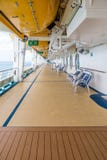 Sedie sulla piattaforma della nave da crociera sotto le lance di salvataggio Fotografia Stock Libera da Diritti