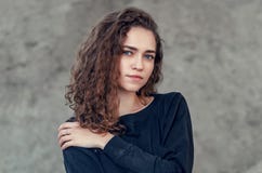 Seductive beautiful curly girl, portrait on gray background