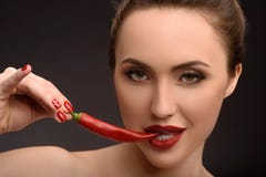 Seductive girl eating spicy red pepper stock photo Seductive girl eating spicy red pepper stock photo