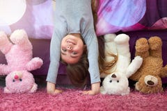 Seeing the world from a new perspective. Portrait of a cute little girl doing a handstand in her bedroom at home.