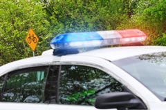 Segnale stradale della bici o della bicicletta con il fuoco selettivo & volante della polizia con immagini stock Segnale stradale della bici o della bicicletta con il fuoco selettivo & volante della polizia con immagini stock