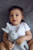 Sehr nettes Baby in der weißen Kleidung, die auf dem Bett liegt Lizenzfreie Stockbilder Sehr nettes Baby in der weißen Kleidung, die auf dem Bett liegt Lizenzfreie Stockbilder