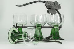 Seis copas de vino con los troncos verdes que se sientan en un hierro labrado atormentan fotografía de archivo libre de regalías Seis copas de vino con los troncos verdes que se sientan en un hierro labrado atormentan fotografía de archivo libre de regalías