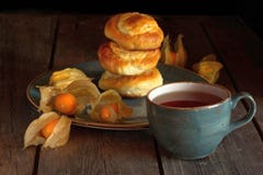 Selbst gemachte Rollen mit Hüttenkäse und Physalis und eine Tasse Tee auf einem Holztisch stockfotografie Selbst gemachte Rollen mit Hüttenkäse und Physalis und eine Tasse Tee auf einem Holztisch stockfotografie