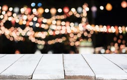 Selective Empty wooden table in front of abstract blurred festive light background with light spots and bokeh for product montage stock images Selective Empty wooden table in front of abstract blurred festive light background with light spots and bokeh for product montage stock images