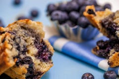 Selective focus of blueberry muffin half with blueberries and muffin pieces stock image Selective focus of blueberry muffin half with blueberries and muffin pieces stock image