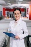 selective focus of smiling shop assistant in white coat with notepad in furniture shop stock image selective focus of smiling shop assistant in white coat with notepad in furniture shop stock image