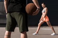 selective focus of sportsman with basketball ball and sportswoman stretching stock images selective focus of sportsman with basketball ball and sportswoman stretching stock images