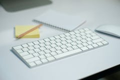 Selective focus on white keyboard on the desk with defocused stationary, and mouse in background royalty free stock photos Selective focus on white keyboard on the desk with defocused stationary, and mouse in background royalty free stock photos