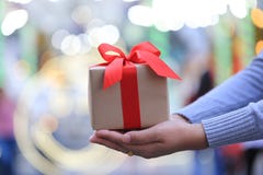 Selective focus of Woman hand holding gift box with red ribbon for Christmas and New Year`s Day or Greeting season royalty free stock image Selective focus of Woman hand holding gift box with red ribbon for Christmas and New Year`s Day or Greeting season royalty free stock image