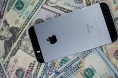 Selinsgrove, PA, США - 31-ое марта 2019: IPhone Яблока сидит поверх кучи валюты Соединенных Штатов стоковое изображение Selinsgrove, PA, США - 31-ое марта 2019: IPhone Яблока сидит поверх кучи валюты Соединенных Штатов стоковое изображение
