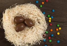 Semana Santa Los huevos de chocolate con los caramelos multicolores mienten en una jerarqu?a en una tabla blanca de madera fotografía de archivo libre de regalías Semana Santa Los huevos de chocolate con los caramelos multicolores mienten en una jerarqu?a en una tabla blanca de madera fotografía de archivo libre de regalías