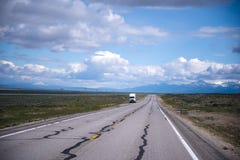 Semi truck staying out of road in Nevada. The view from the endless road endless plains, picturesque cloudy sky and a small semi truck standing on the roadside stock image Semi truck staying out of road in Nevada. The view from the endless road endless plains, picturesque cloudy sky and a small semi truck standing on the roadside stock image