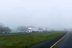 Semi trucks trailers big rigs cargo convoy on foggy highway Royalty Free Stock Photos Semi trucks trailers big rigs cargo convoy on foggy highway Royalty Free Stock Photos