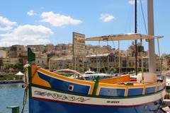 Senglea Malta, Juli 2016 Berömd maltesisk fiskebåt på bakgrunden av den gamla staden fotografering för bildbyråer Senglea Malta, Juli 2016 Berömd maltesisk fiskebåt på bakgrunden av den gamla staden fotografering för bildbyråer