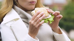 Senhora grávida que come o hamburguer com apetite saudável do presunto e da salada fresca, hora do almoço filme Senhora grávida que come o hamburguer com apetite saudável do presunto e da salada fresca, hora do almoço filme