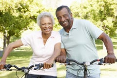 Senior African American Couple Cycling In Park